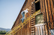 © Inti St Clair/Blend Images - Caucasian farmer climbing ladder to barn