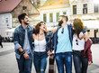 © BalanceFormCreative - Group of friends laughing and walking at the city downtown.They embrace each other and smiling.