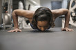 © JGI/Tom Grill/Blend Images - Mixed Race woman doing push-up on floor at gymnasium