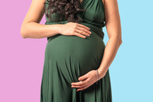 Pregnant Woman Embracing Belly With Pink And Blue Background