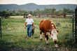 © Inti St Clair/Blend Images - Caucasian farmer and dog walking with cow