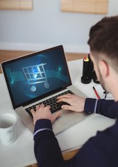 Wall Mural - person using laptop with shopping trolley icon