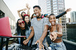 © Peathegee Inc/Blend Images - Friends posing with DJ on urban rooftop