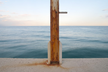 rusty flag pole at the sea edge