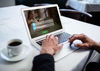 Wall Mural - In a restaurant, hands with laptop. Login screen