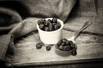 Wall Mural - Pot of blueberries with spoon on a rustic background