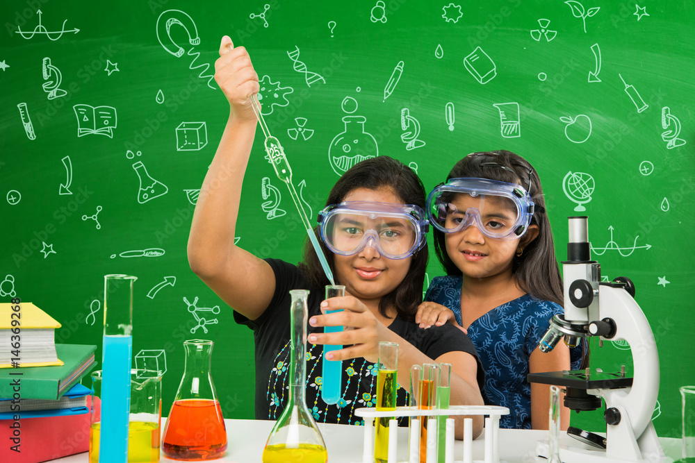 2 cute little indian girls doing science experiment or project in a ...