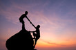 Teamwork couple hiking help each other trust assistance silhouette in mountains, sunset. Teamwork of man to success