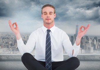 Poster - Business man meditating against grey skyline and clouds