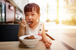 Leinwandbild Motiv Asian little Chinese girl eating braised pork rice