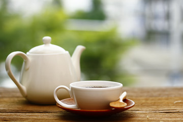 Wall Mural - Stock Photo - Cup of coffee on table in Morning light