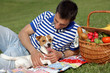 © dream@do - Happy smiling man resting at a picnic in park with a dog Jack russell terrier. Lunch break outdoors , Time for relax, Leisure Lifestyle Concept