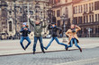 © EdNurg - group of happy friends jumping in the old city street near the castle in Dresden, Germany
