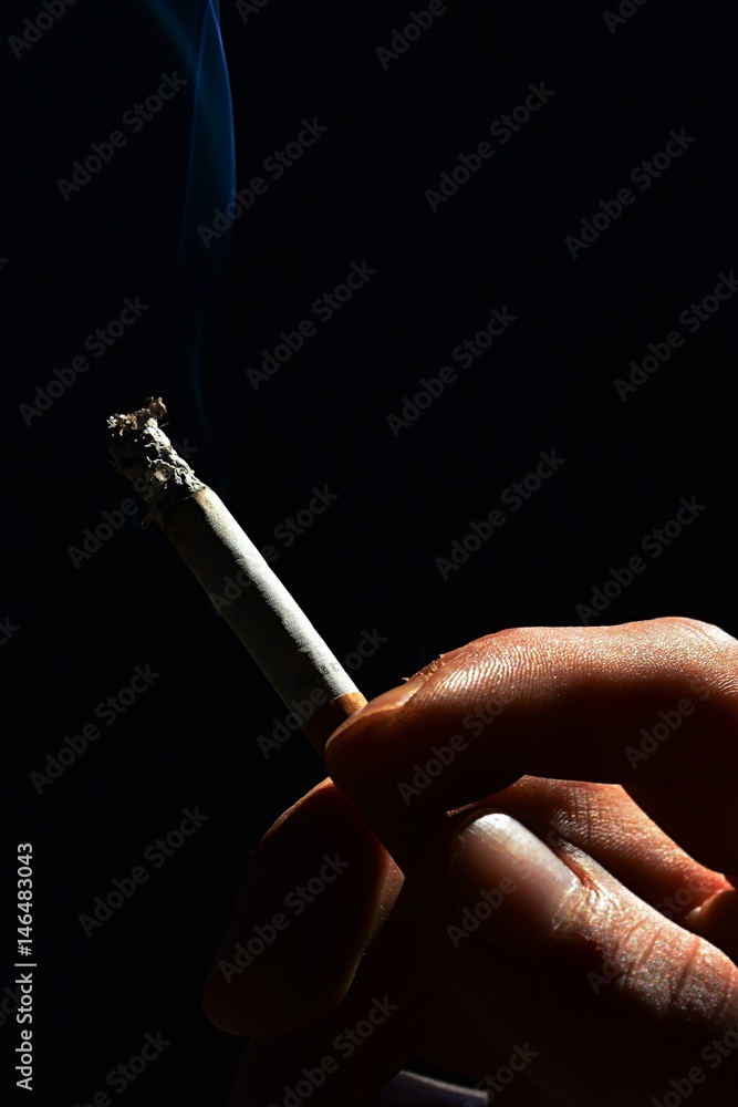 cigarette dark Fingers of adult man holding smoking cigarette on dark background Stock  Photo