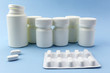 © digicomphoto - Pills boats white with white tablets of different types on blue background