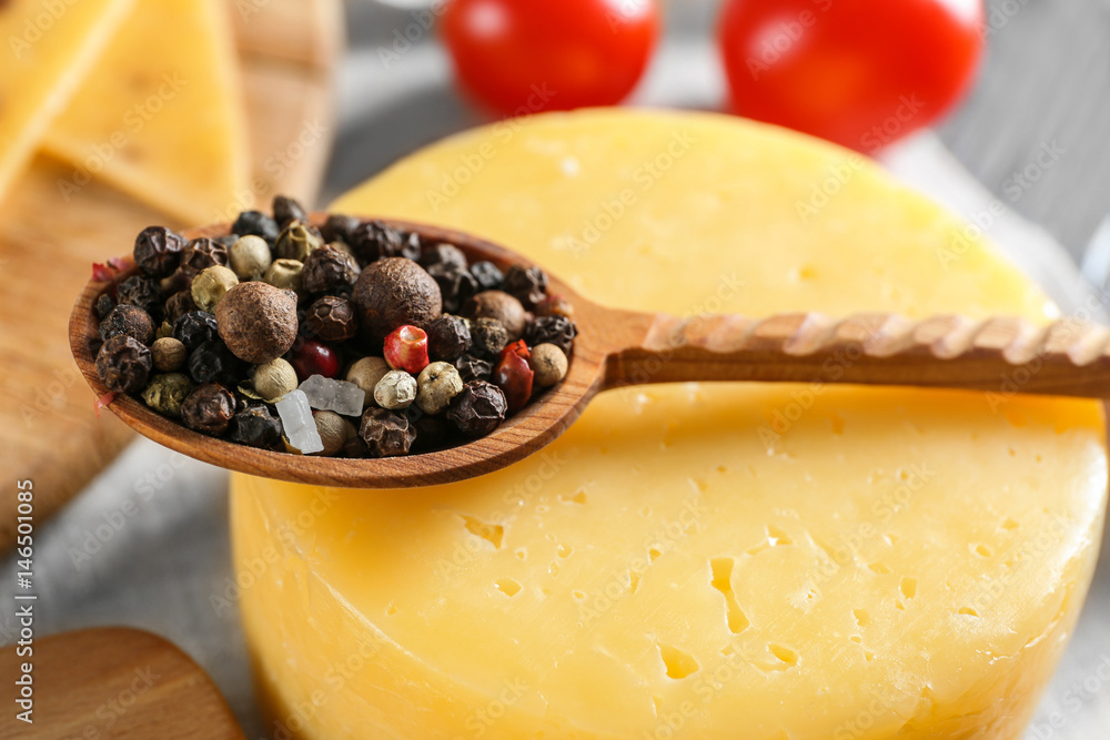 Wooden spoon with mixture of peppers on cheese head