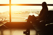 © Jag_cz - Silhouette of a young woman traveler waiting at the airport for departure
