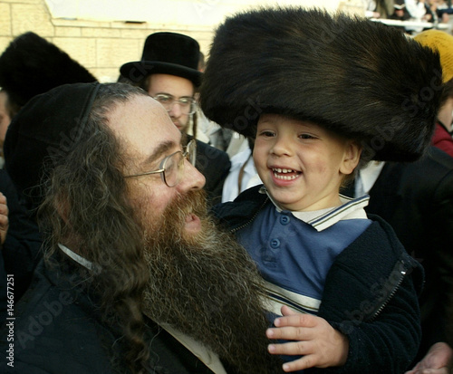 An Ultra Orthodox Jew Holds A 3 Year Old Boy After Having His Hair