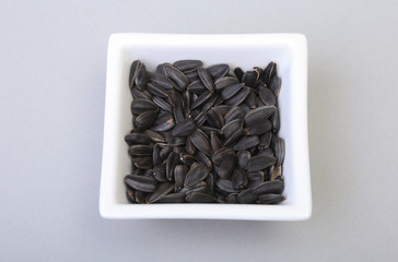 Bowl with sunflower seeds isolated white background.