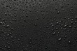 Drops of water on a black surface. The condensate. Top view. Free space.