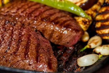 Wall Mural - fried beef with eggplant, chili pepper, garlic on pan, close up