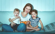 © JenkoAtaman - Family mother and children watching television at home