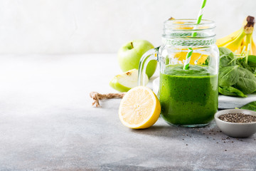 Healthy breakfast with green smoothie in glass jar and ingredients. Detox, diet, healthy, vegetarian food concept with copy space.