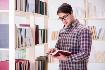 Young student looking for books in college library