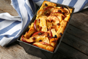 Wall Mural - Freshly baked bread pudding in casserole dish on wooden table