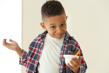 Wall Mural - Cute African American boy with yogurt at home