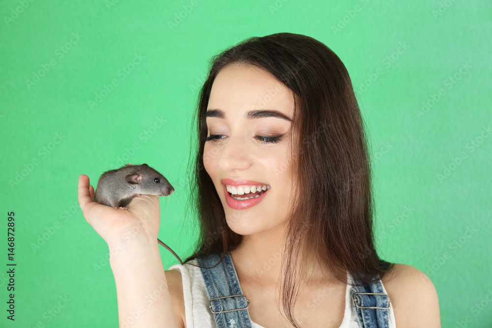 Young woman with funny rat on color background