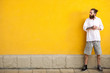 © DC Studio - Tattooed bearded hipster on yellow wall posing outdoor