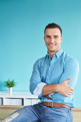 Wall Mural - Smiling businessman sitting on desk in office