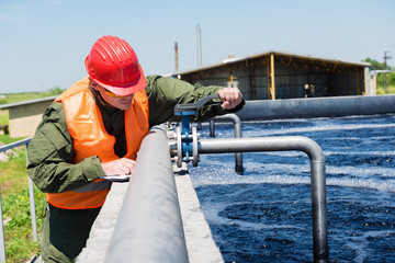 An engineer controlling a quality of water ,aerated activated sludge tank at a waste water treatment plant