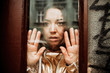 © pyrozenko13 - Look from the outside at woman in golden suit behind glass door