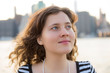 © Andriy Blokhin - Closeup of young woman smiling looking up dreaming with New York City skyline in background