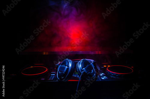 dj-spinning-mixing-and-scratching-in-a-night-club-hands-of-dj-tweak-various-track-controls-on-dj-s-deck-strobe-lights-and-fog-selective-focus-close-up-dj-music-club-life-concept