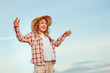 © mashiki - happy child girl in country style plaid shirt and hat relaxing on summer field with hay stacks