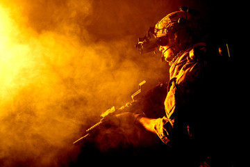 Canvas Print - Security forces operator in Combat Uniforms with rifle, in the face of danger. Facing enemy, he is ready to fight. Studio contour silhouette shot, toned and colorized, backlight, profile side view