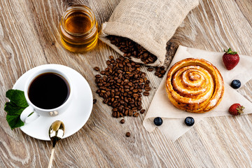 Wall Mural - Cup of coffee and pastry on wooden background