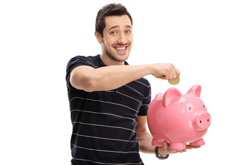 Poster - Happy young man putting a coin into a piggybank