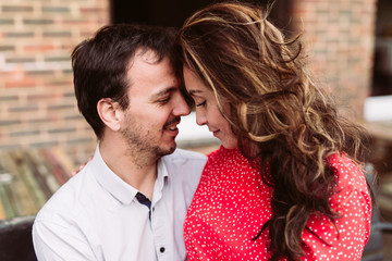 Couple in love, red dress, sitting together in city