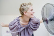 © Connect Images - Woman leaning near fan