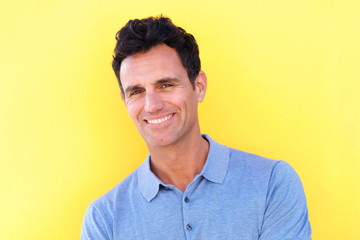 Wall Mural - handsome man smiling against yellow background