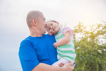 Wall Mural - Asian father holding his daughter in park