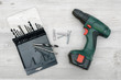 © gearstd - A cordless drill set to stand on a wooden table background with a set of bits in the box