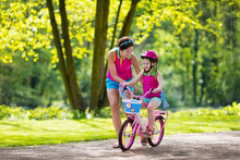 Mother Teaching Child To Ride A Bike