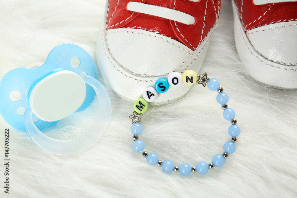Composition with baby name bracelet on white fluffy background