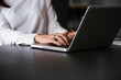© bnenin - Side view and close up of woman's hands typing on laptop keyboard