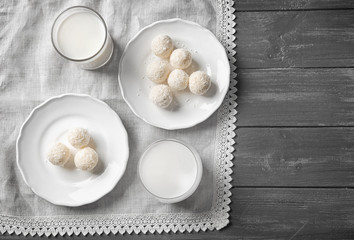 Wall Mural - Plates with tasty candies in coconut flakes on wooden background